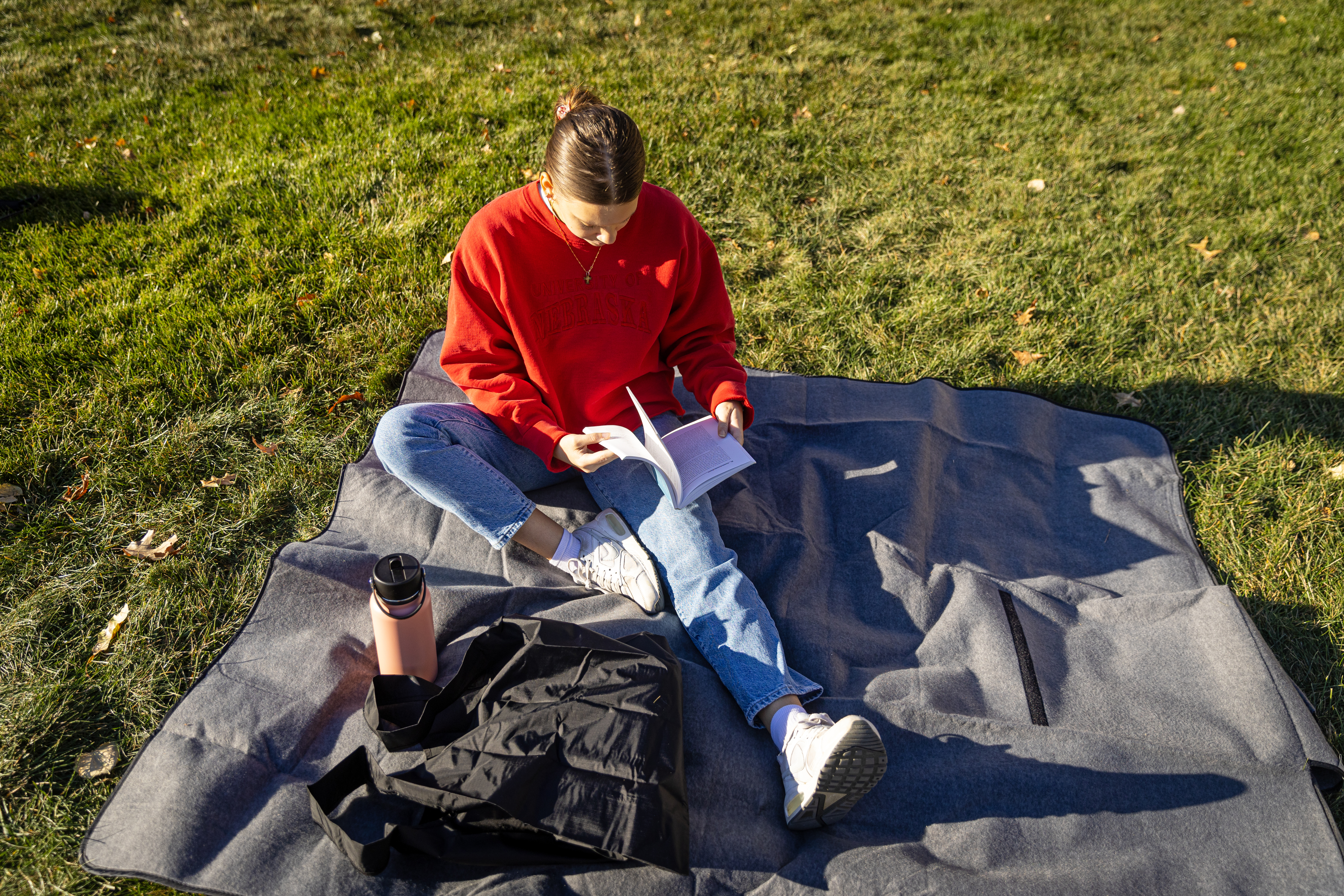 Student studies on the lawn outside Love Library
