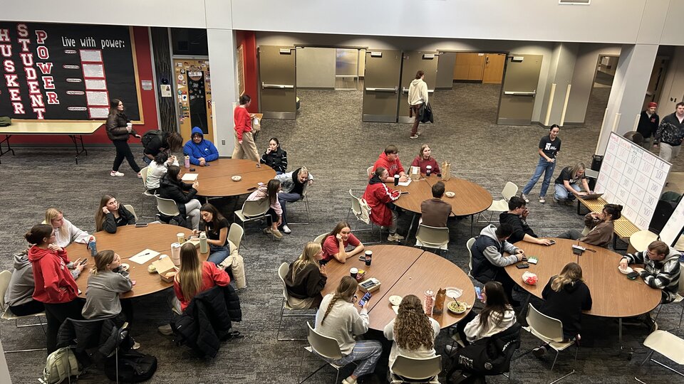 Students sit at a table and learn about recycling