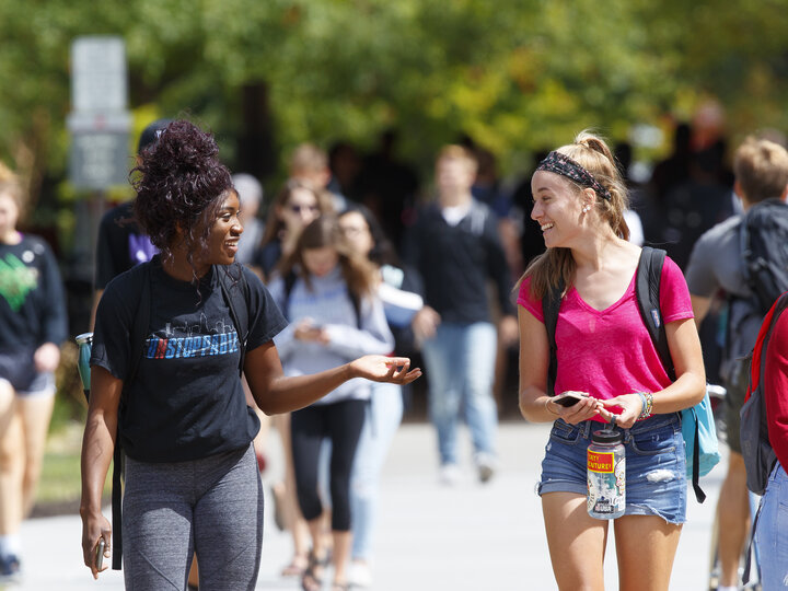 Students talk on campus outside