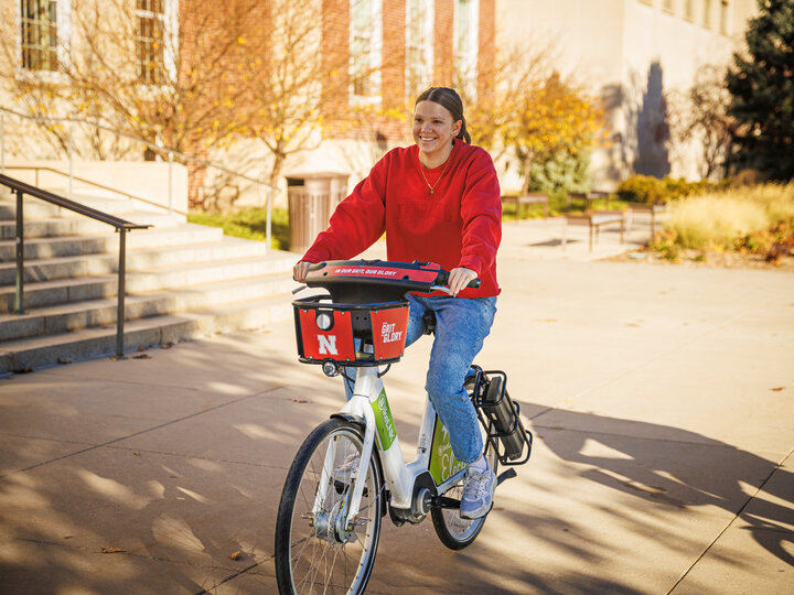 A person rides a bike on campus