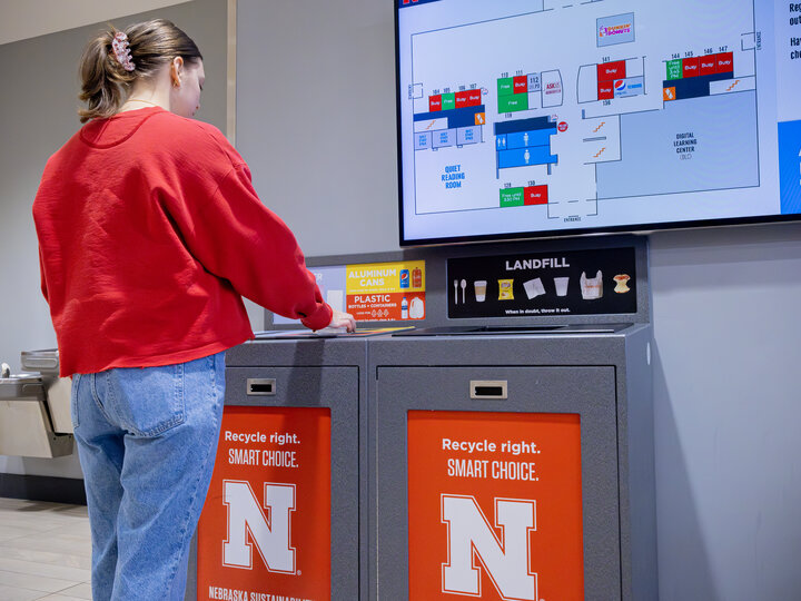 Student recycles at an All in the Hall station