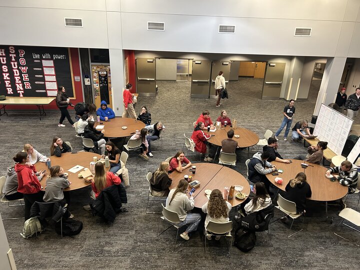 Students sit at a table and learn about recycling