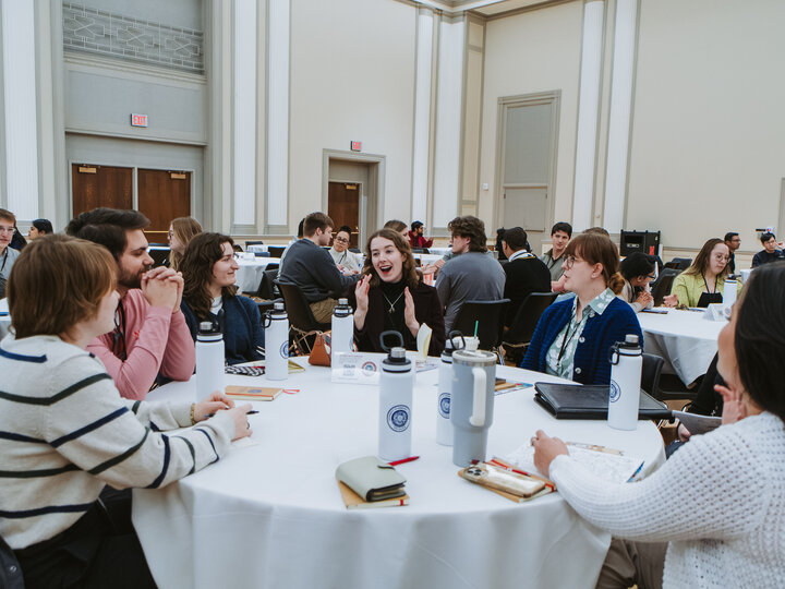 Group of attendees at a table having a discussion.