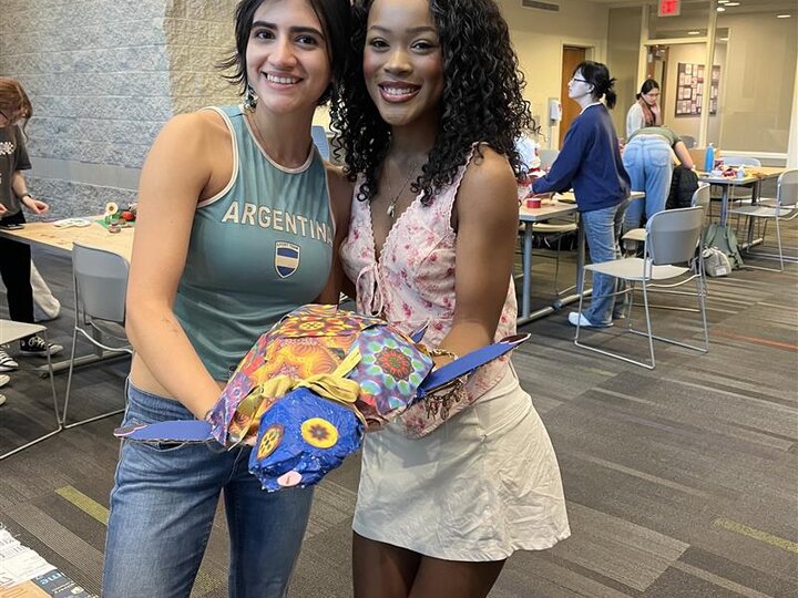 Students hold their winning art piece made out of waste items